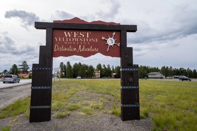 Westgate Theatre sign in West Yellowstone with scenic background.